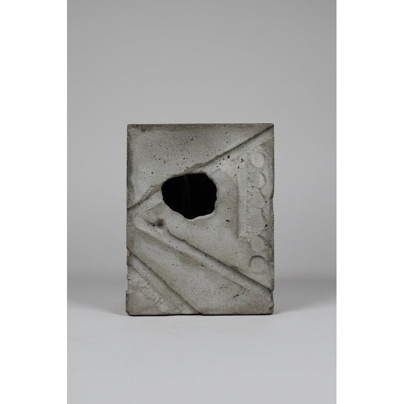 Concrete block with a square hole in a concrete wall