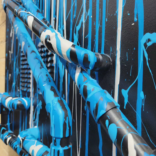 Blue and white drips on black with pipes industrial canvas. Video